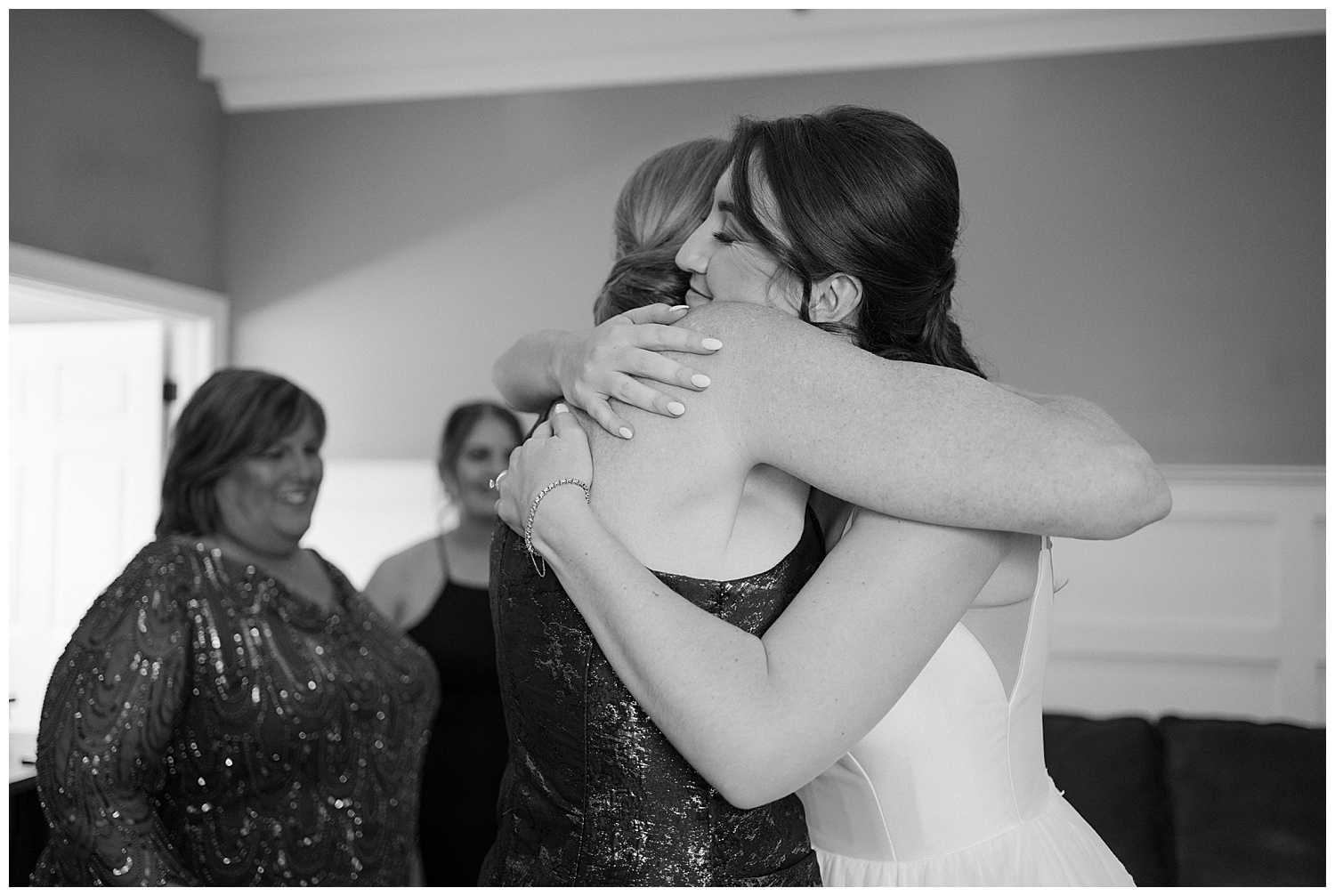 Bride and mom hugging in getting ready space at wedding venue
