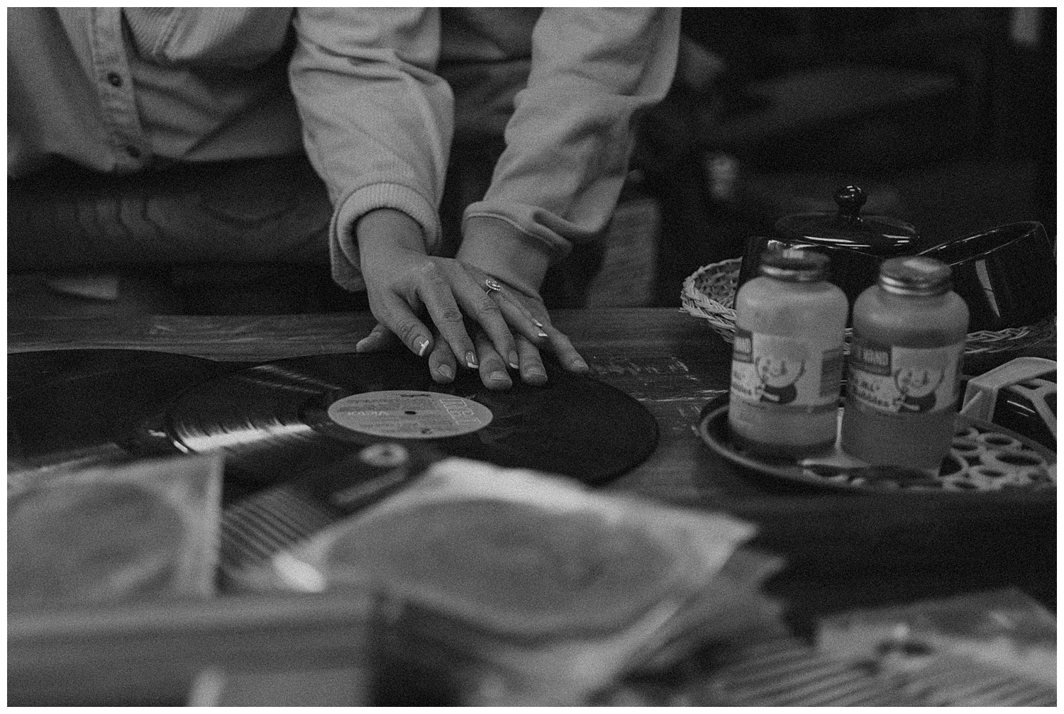 Black and white photo of hands on record